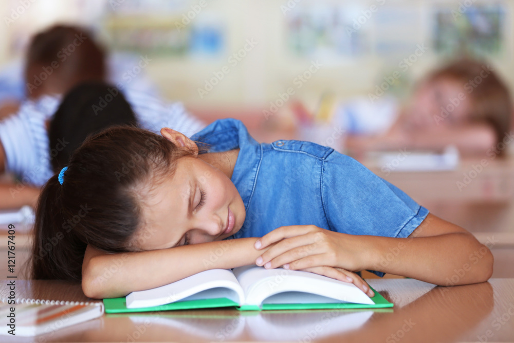 Tired schoolgirl in classroom on lesson Tired schoolgirl in classroom on lesson