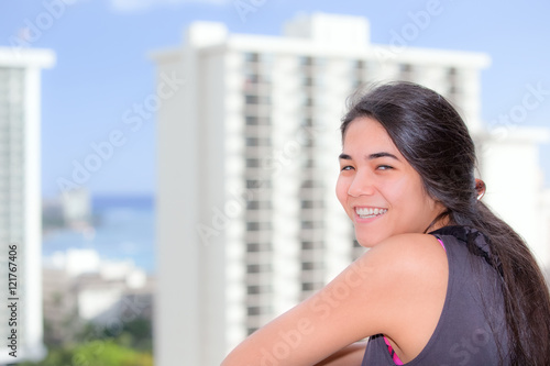 Free Download Biracial teen girl standing on highrise balcony of urban city - GFXLoad
