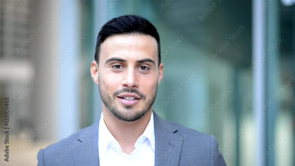 Young businessman talking while looking at the camera Young businessman talking while looking at the camera