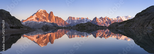 Panorama of Alps mountain with sunset light reflecting in lake © NicoElNino