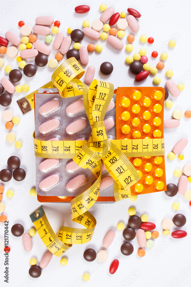 Obraz premium Blisters of medical pills and capsules wrapped centimeter, health care healthy lifestyle and slimming concept
