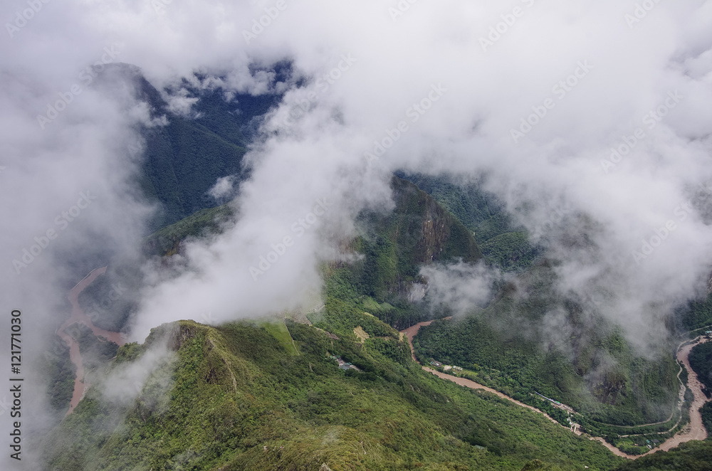 View from  terraces of Lost Inca City of Machu Picchu to canyon of river Urubamba . Low clouds. Cusco Region,Sacred Valley, Peru