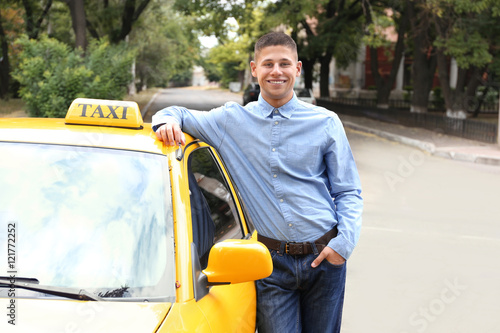 Male taxi driver near car