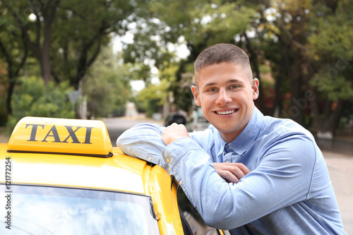 Male taxi driver near car