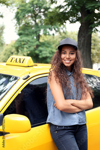 Female taxi driver near car