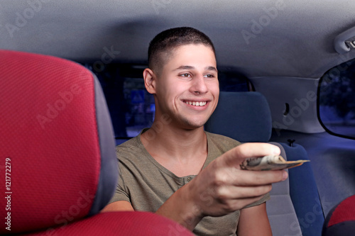 Handsome man paying for taxi