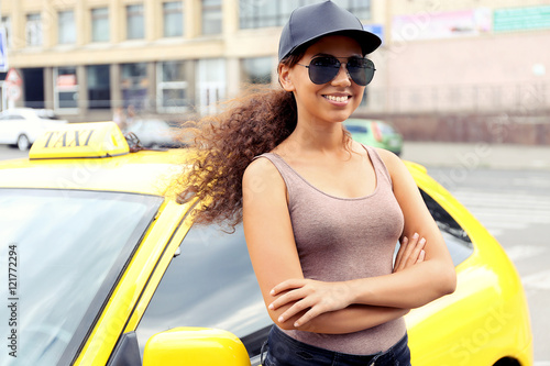 Female taxi driver near car
