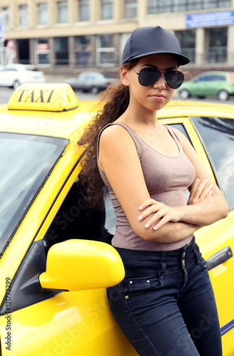 Female taxi driver near car