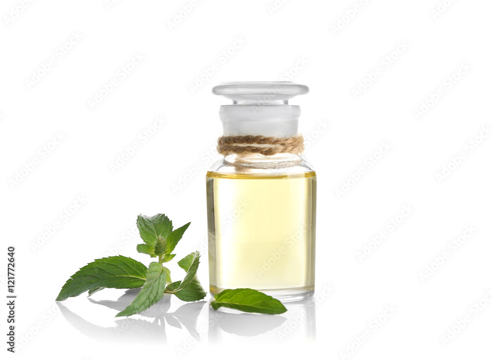 Essential aroma oil in glass bottle with fresh mint leaves on white background Essential aroma oil in glass bottle with fresh mint leaves on white background