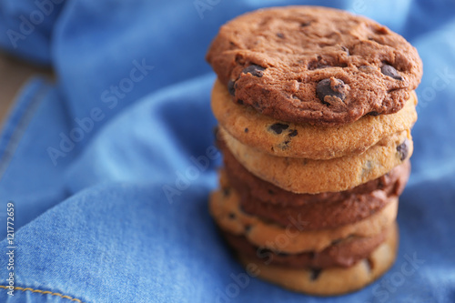 Fresh oat biscuits with chocolate on fabric background photo