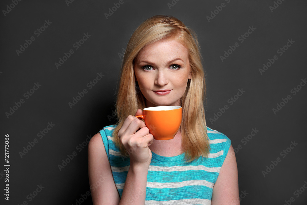 Beautiful girl with cup of coffee on grey background Beautiful girl with cup of coffee on grey background