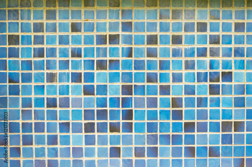 the old, dirty, alkali, rust dark blue and brown chipped wall tiles of the building background texture