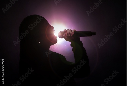 Women singing under bright spotlight photo