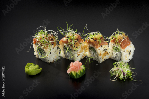 Fresh Uramaki maki Sushi rolls over black background