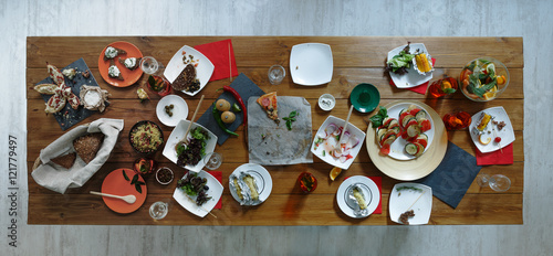 фотографія After party. Wasted food on wooden served festive table