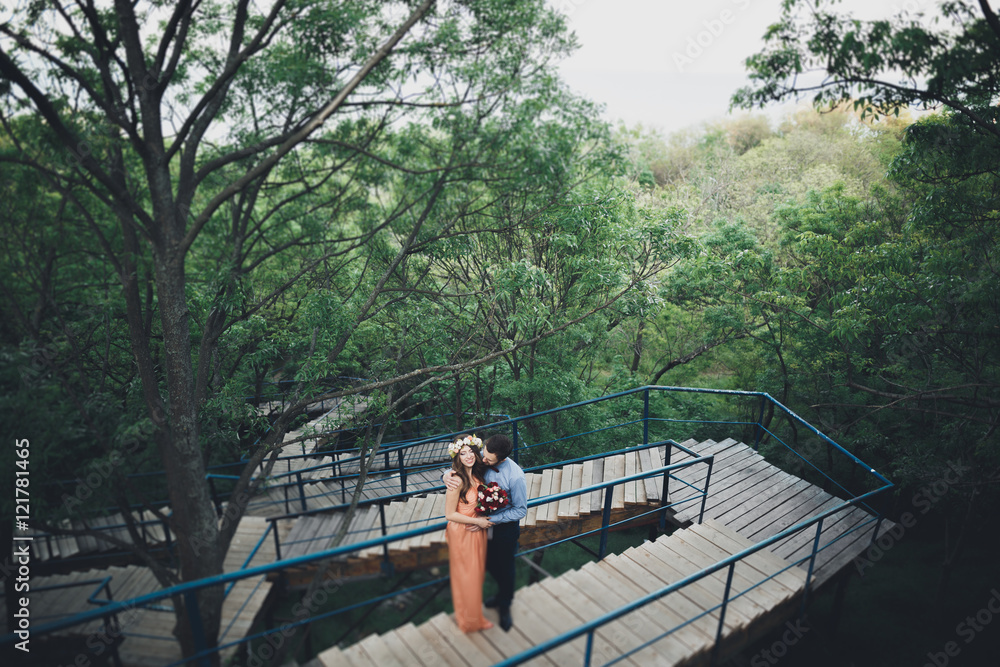 Fototapeta premium Stylish beautiful happy wedding couple kissing and embracing in Botanical Garden