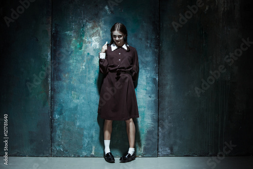 Portrait of a young smiling girl in school uniform as killer woman