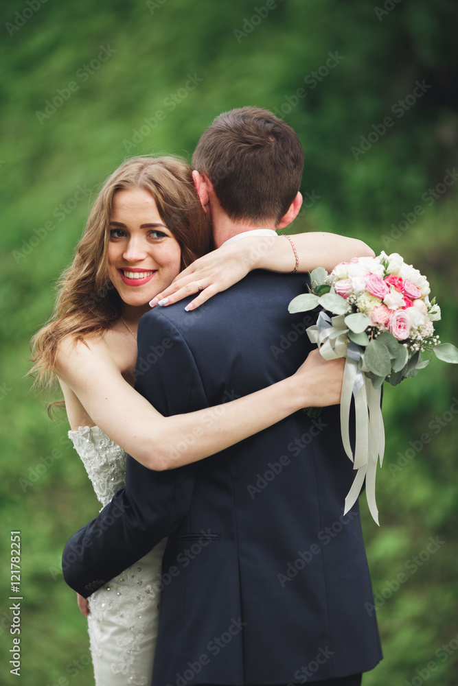 Happy wedding couple hugging and smiling each other on the background gorgeous plants in castle