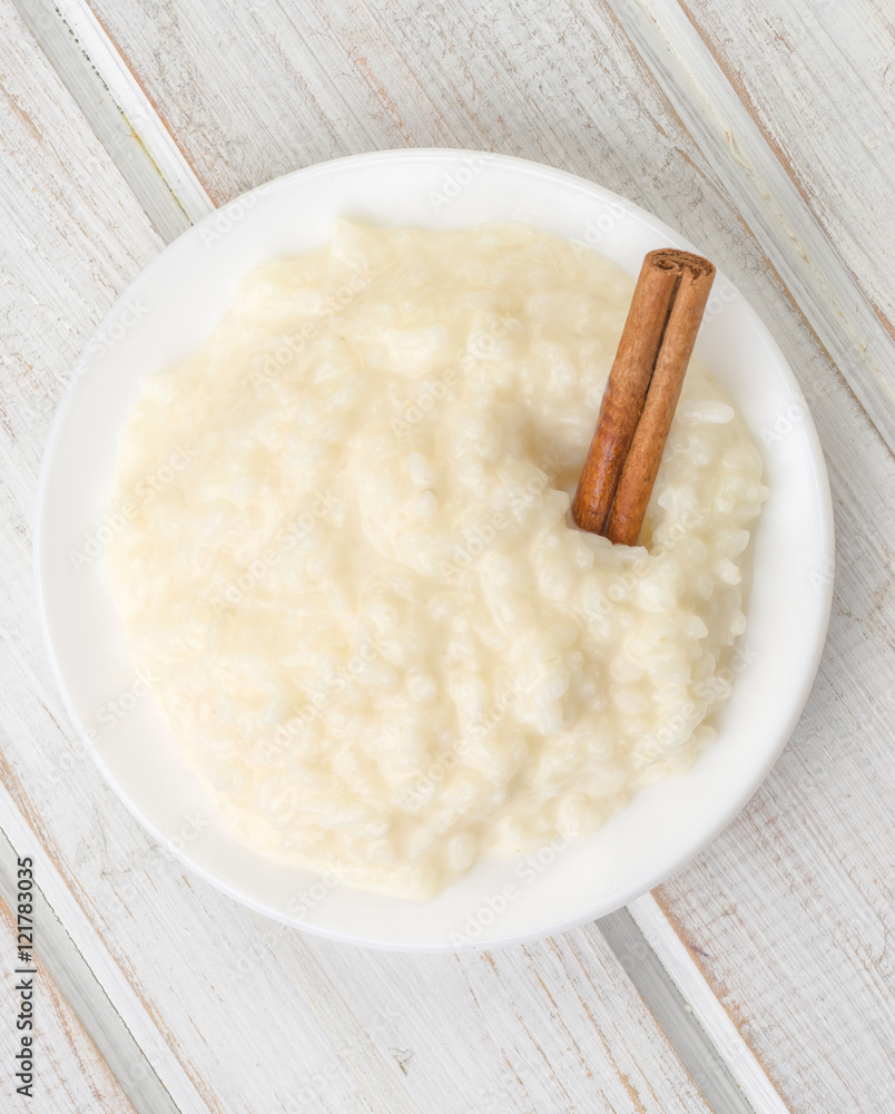 overhead shot pile of rice pudding on porcelain plate, on wood overhead shot pile of rice pudding on porcelain plate, on wood