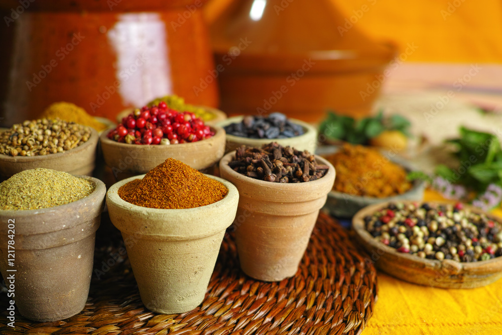 Collection of different spices in old clay bowls in colorful oriental style