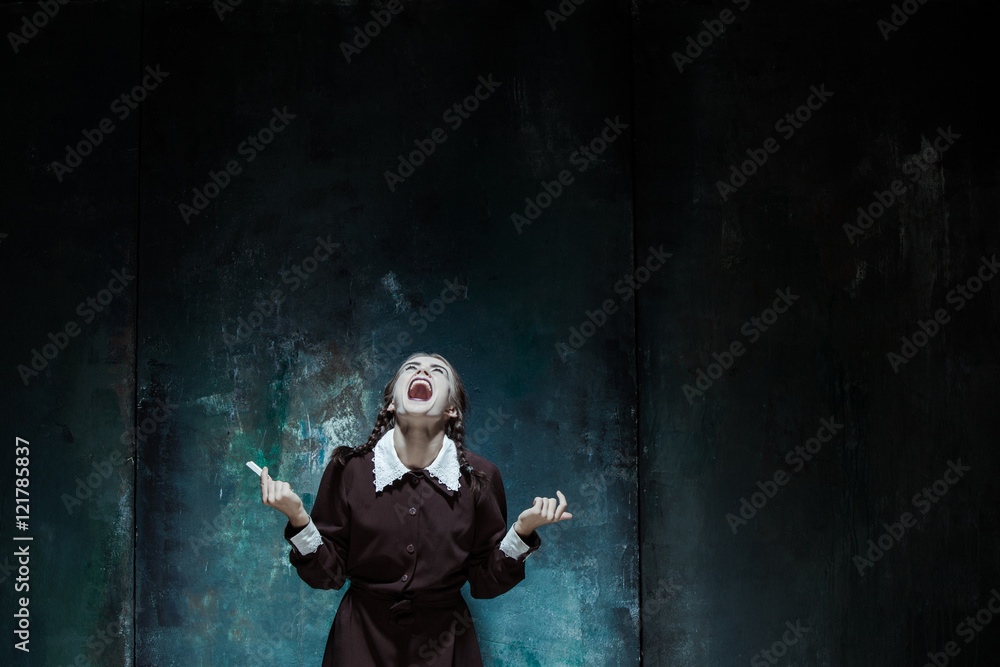 Portrait of a young smiling girl in school uniform as killer woman