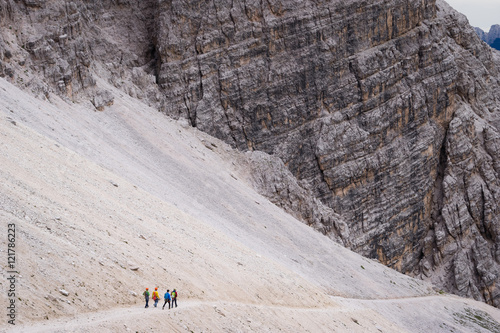 Four Mountaineers on a mountain trail. Hiking in a italian dolomites. UNESCO World Heritage Site.