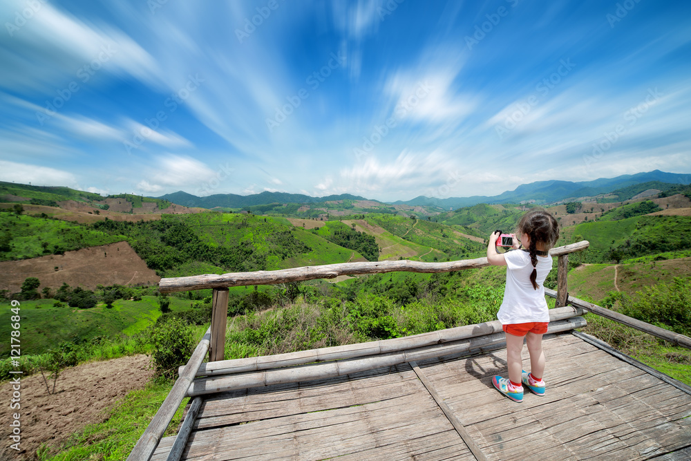 Little girl taking a photograph on viewpoint, Nan Thailand