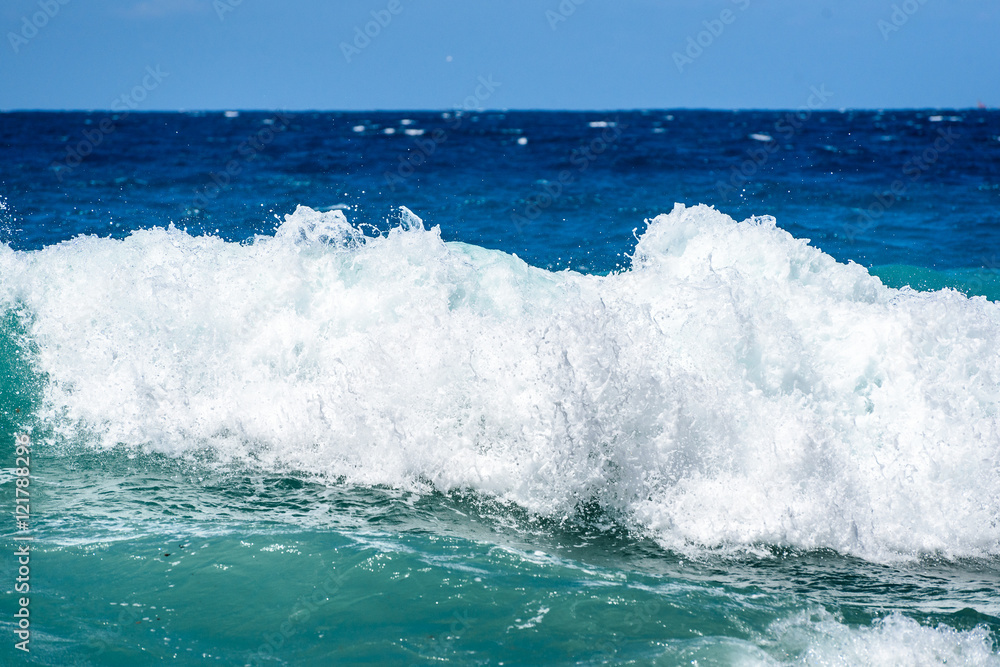 Strong winds and waves are hitting a beach or coast.