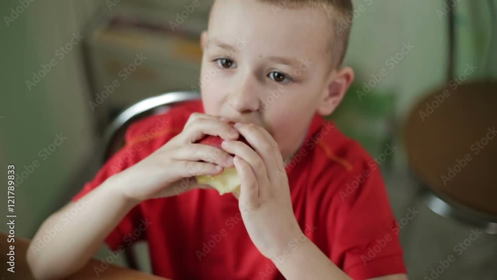 Small beautiful boy with big eyes eating an apple appetizing. Small beautiful boy with big eyes eating an apple appetizing.