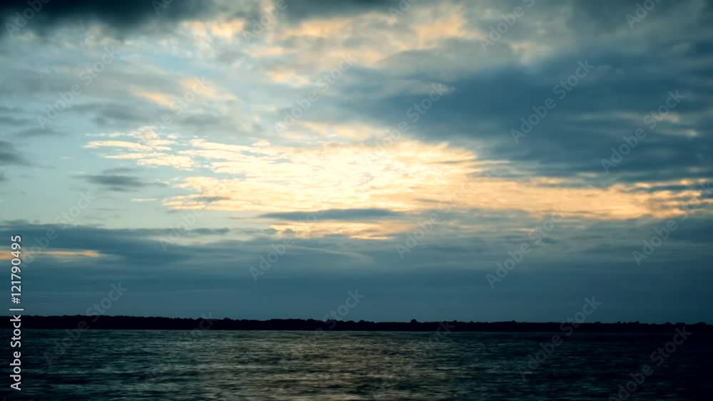 Dramatic cirrus and cumulus clouds at dawn over river or lake. Time-lapse. Dramatic cirrus and cumulus clouds at dawn over river or lake. Time-lapse.