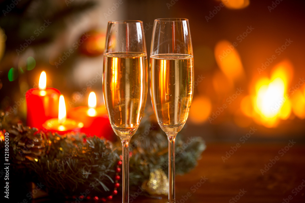 Closeup image of glasses of champagne in front of Christmas wrea Closeup image of glasses of champagne in front of Christmas wrea