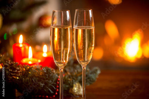 Closeup image of glasses of champagne in front of Christmas wrea