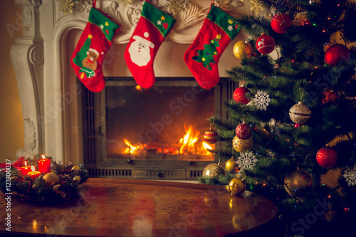 Toned image of wooden table in front of decorated fireplace and