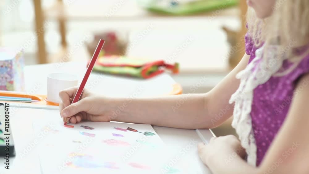 Profile of a beautiful little girl with long white hair. Girl sitting at the desk and drawing with colored pencils. Children's drawing. The child is busy drawing. Portrait of a drawing girl Profile of a beautiful little girl with long white hair. Girl sitting at the desk and drawing with colored pencils. Children's drawing. The child is busy drawing. Portrait of a drawing girl