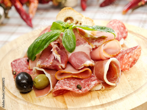 Salami and Ham on a wooden board. Close up photo