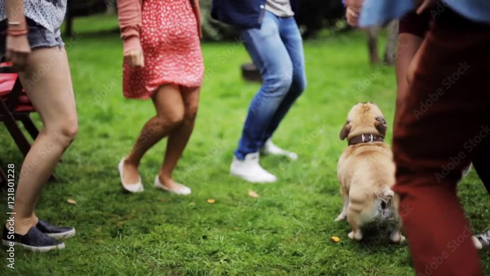 happy friends dancing at summer party in garden