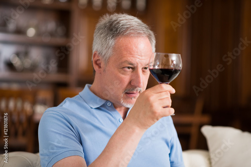 Mature man enjoying a glass of red wine