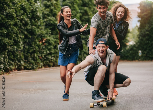 Group of teenagers enjoying outdoors with skateboard