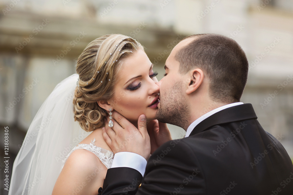 Wedding. Wedding kiss. Elegant bride and groom kissing after wedding ceremony. Portrait of bride and groom. Wedding makeup and hairstyle. Wedding concept