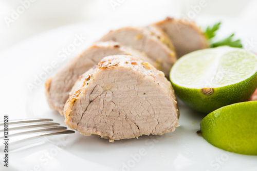 Sliced lime pork tenderloin on white background close up. Healthy food.