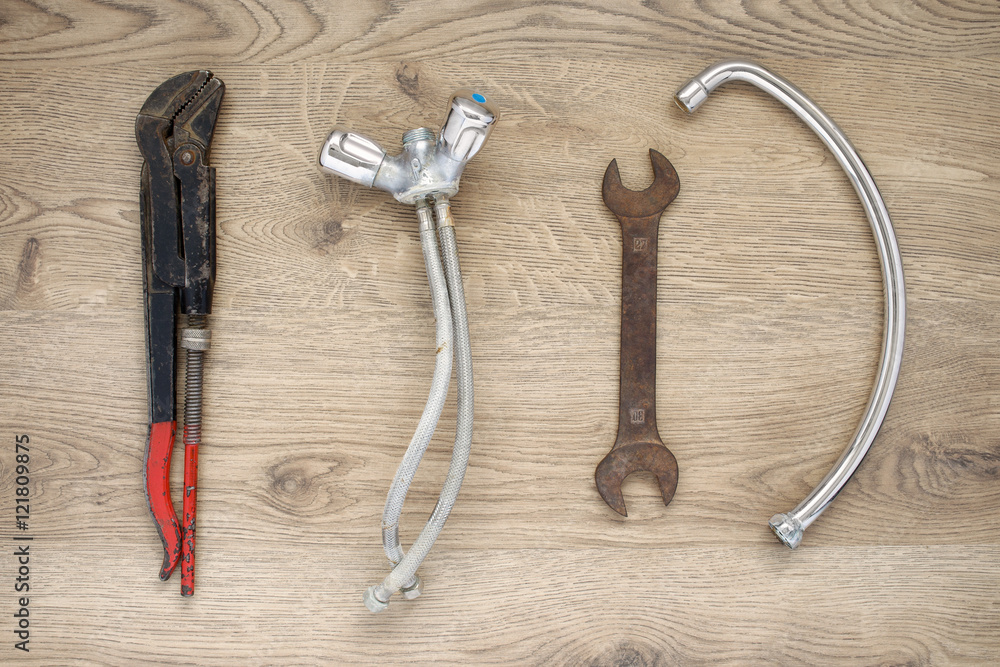 Old plumbing tools and tap on wooden background Old plumbing tools and tap on wooden background