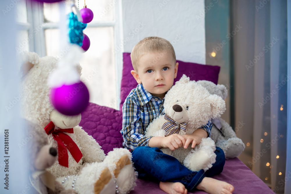 Portrait of a dreamy boy 3-4 years, holding a white teddy bear Portrait of a dreamy boy 3-4 years, holding a white teddy bear