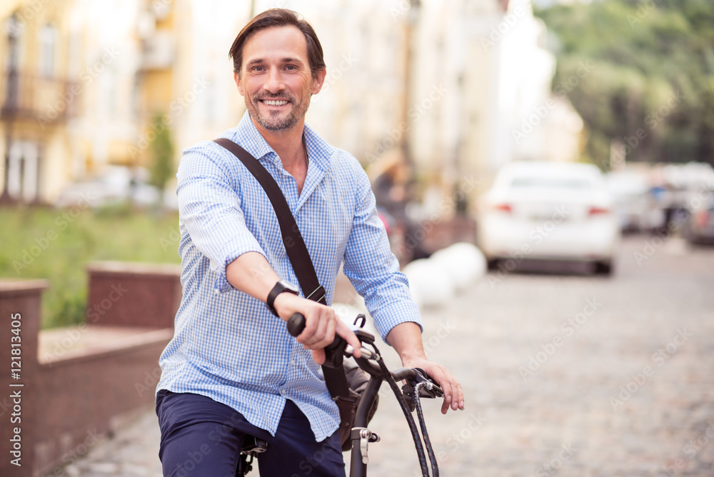 Cheerful man riding a bike