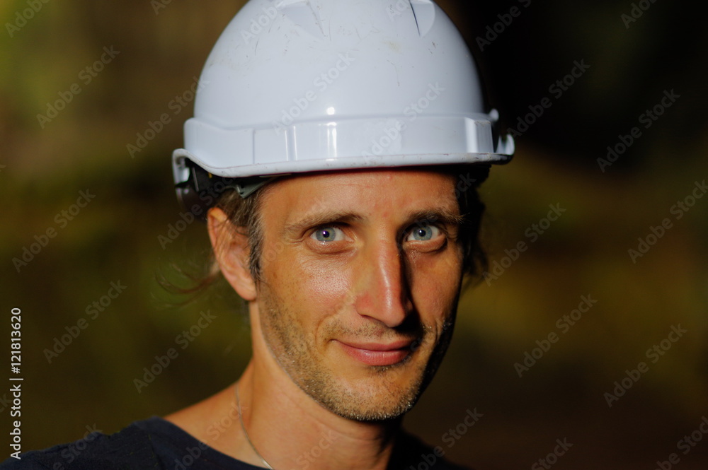 Fototapeta premium portrait of a worker with white helmet on head, nature background