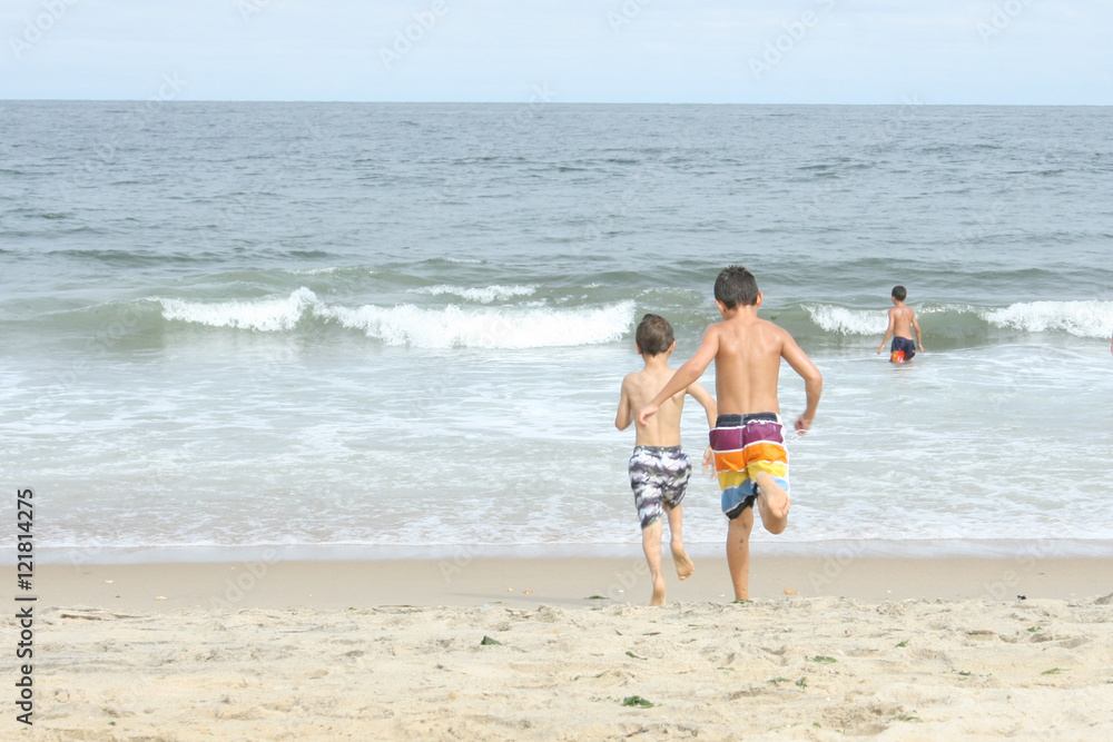 Kids running into the ocean at the beach Kids running into the ocean at the beach