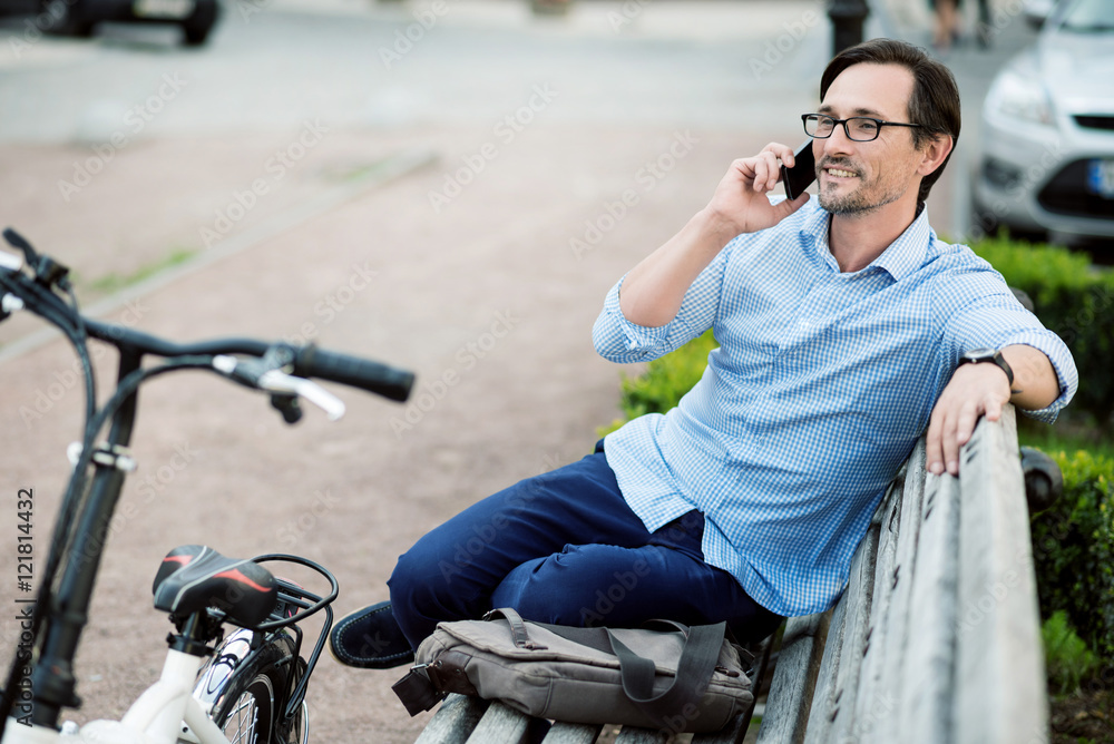 Relaxed bespectacled man speaking on cellphone.