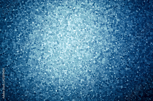 Blue background with light spot of expanded polystyrene. Pattern from slice of polystyrene on a gleam. Transparent, show through material