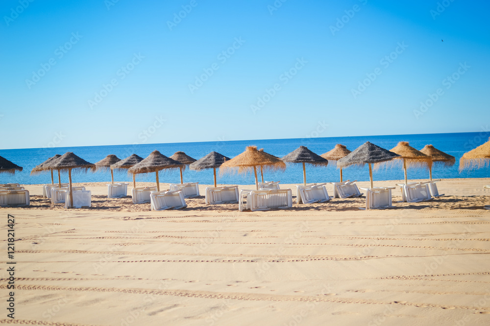 Fototapeta premium Blue sky and straw umbrella on a beautiful tropical beach background