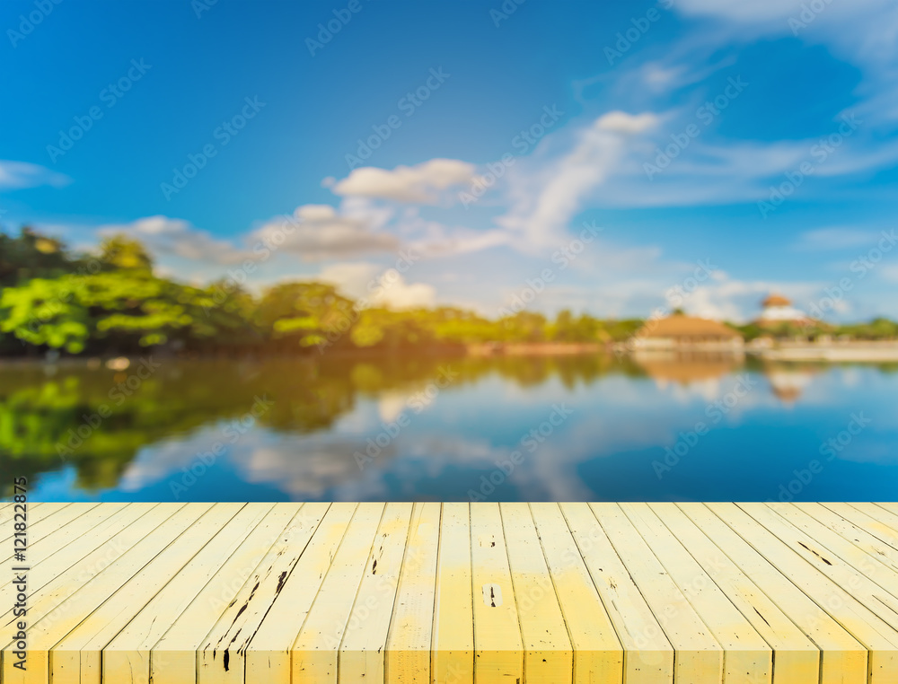   wooden table with blur image of lake.