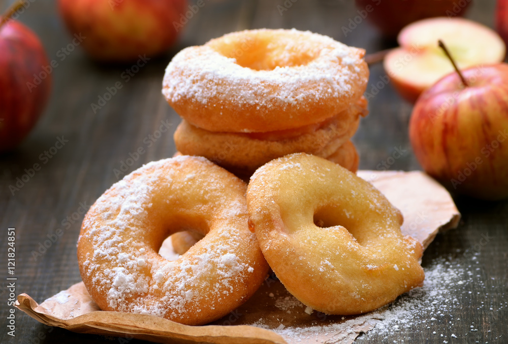 Apple rings over baking paper on wooden table Apple rings over baking paper on wooden table
